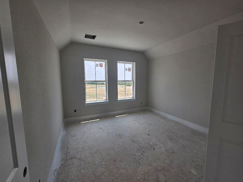 Unfurnished room featuring lofted ceiling and baseboards Unfurnished room featuring lofted ceiling and baseboards