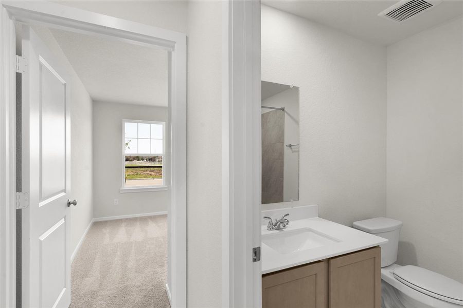 Bathroom with vanity and light colored carpet