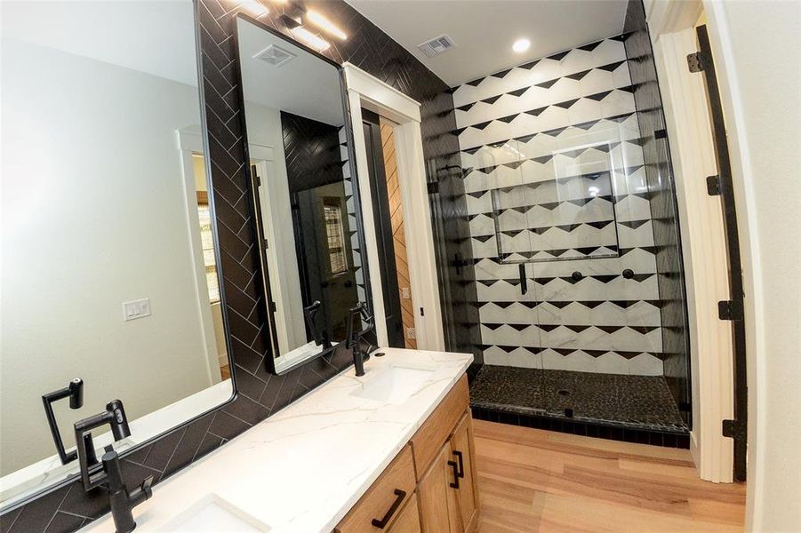 Full bathroom with oversized mirrors and tile walls.