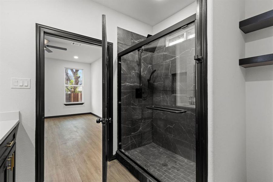 Bathroom featuring wood-type flooring, vanity, a shower with door, and ceiling fan