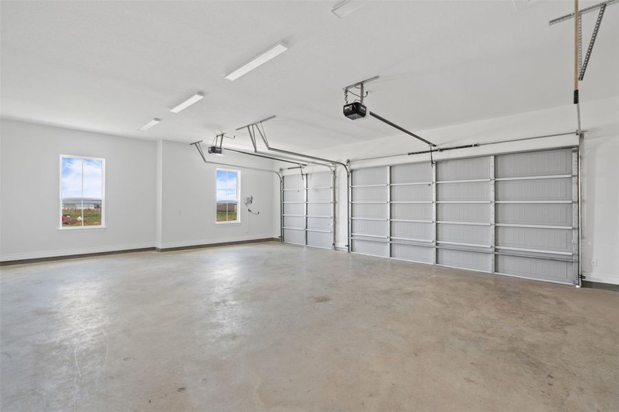 Garage featuring baseboards and a garage door opener Garage featuring baseboards and a garage door opener
