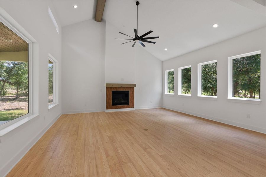 A spacious living area with soaring vaulted ceilings, warm hardwood floors, and a modern fireplace for cozy gatherings.