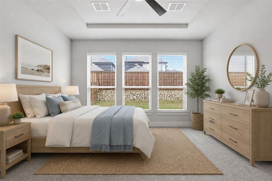 First-floor primary bedroom with a tray ceiling, flooded with natural light and offering plenty of space