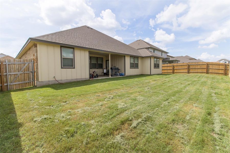 A spacious backyard with a covered patio, perfect for outdoor entertaining.