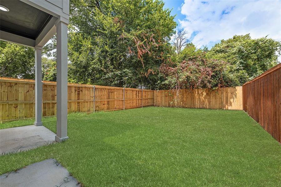 Fenced backyard with a patio area Fenced backyard with a patio area