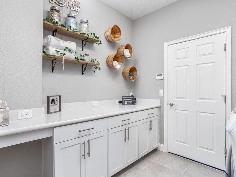 At the garage entry, the spacious laundry room and convenient drop zone keep daily life organized - Waylyn by Highland Homes