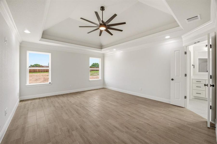 Unfurnished room featuring a ceiling fan, wood finish floors, ornamental molding, plenty of natural light, and recessed lighting