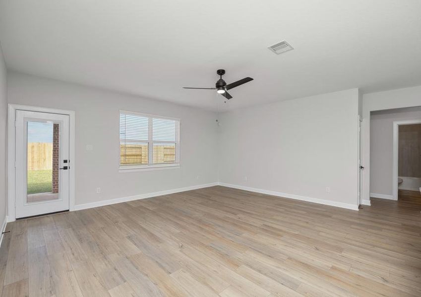 Spacious family room with plank flooring and a ceiling fan