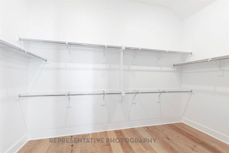 Walk in closet with light wood finished floors