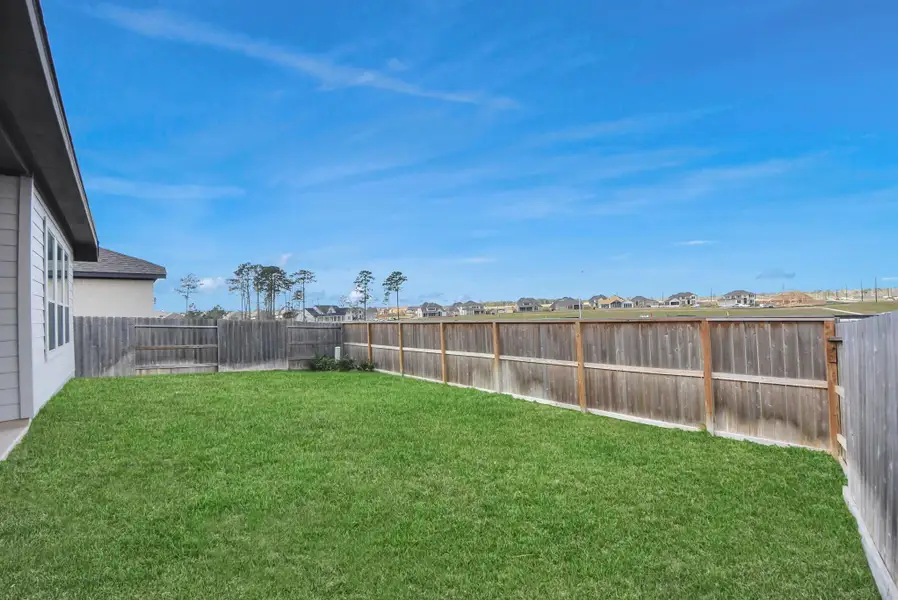 Rear ExteriorThe rear of this modern single-story home showcases a beautifully maintained backyard and a covered patio designed for year-round outdoor enjoyment—perfect for relaxing, entertaining, or family activities.