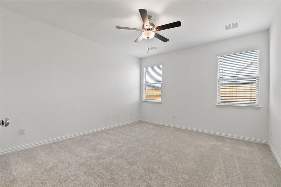 Empty room with light colored carpet and ceiling fan