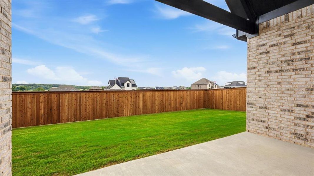 Expansive green lawn with a wood-plank privacy fence