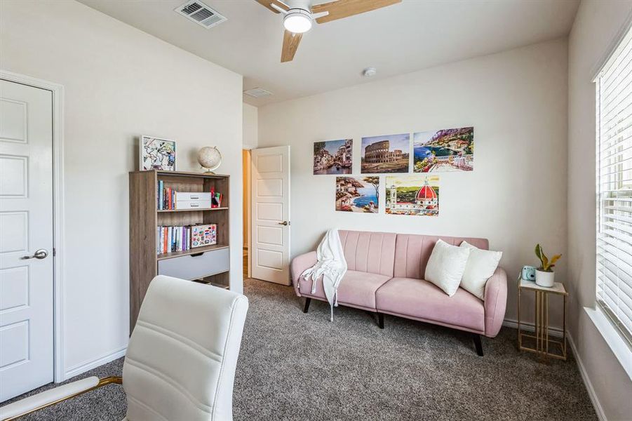 Sitting room featuring ceiling fan and dark carpet