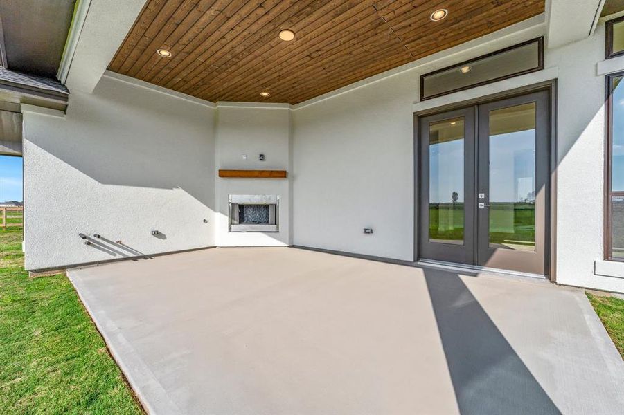 Covered Rear Patio with Wood-burning fireplace and ready for your tv above the mantel. Pre-plumbed for gas, water, and electricity too!