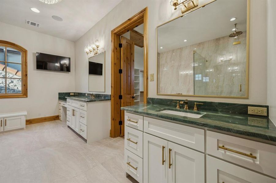 Bathroom with a shower stall, two vanities, recessed lighting, and a spacious closet