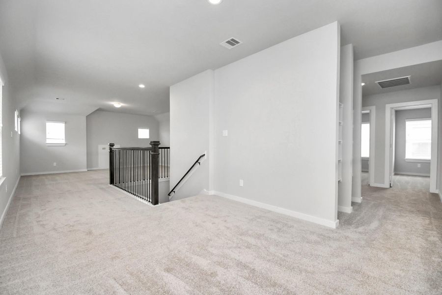 Ascend to relaxation in this fantastic loft and game room area! Ideal for both casual gatherings and adult gaming, it boasts plush carpet, lofty ceilings, custom paint, and ample windows for abundant natural light. Sample photo of completed home with similar floor plan. Actual colors and selections may vary.