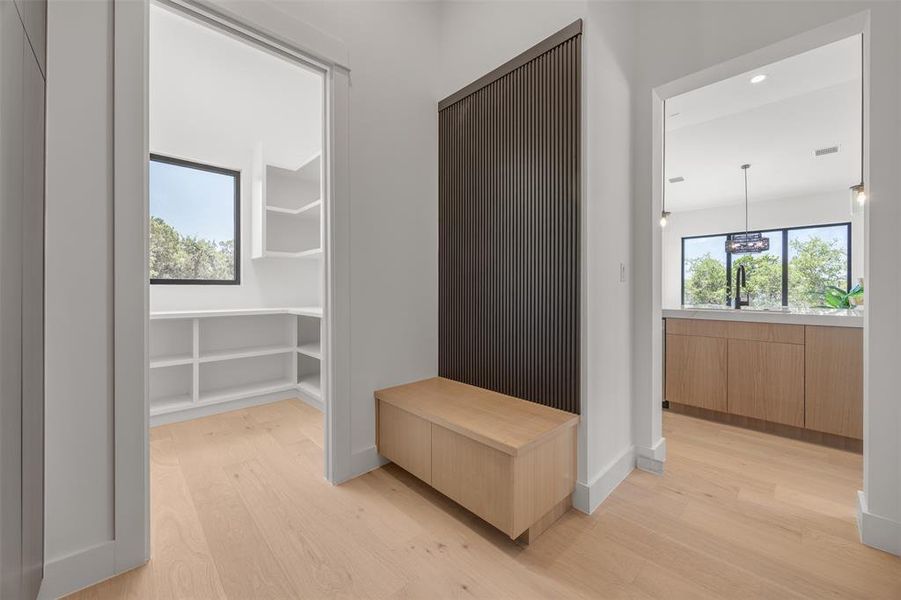 Clean lines and natural light illuminate this well-appointed pantry and adjacent kitchen.