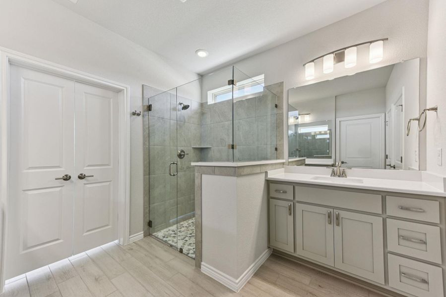 Full bathroom featuring vanity, light wood finished floors, and a stall shower Full bathroom featuring vanity, light wood finished floors, and a stall shower