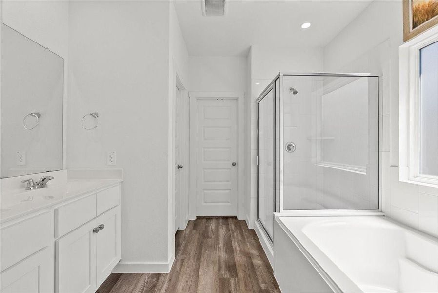 The private primary en-suite bath offers dual vanities, walk-in closet, soaking tub, double sinks, and a walk-in shower.