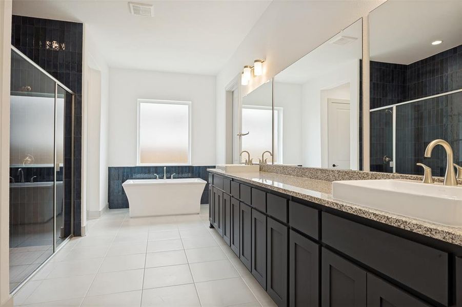 Spacious bathroom featuring a double vanity with stone countertops, undermount sinks, and brushed nickel fixtures Spacious bathroom featuring a double vanity with stone countertops, undermount sinks, and brushed nickel fixtures