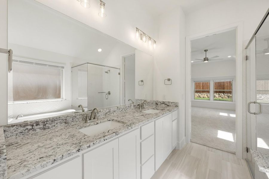 Bathroom with double sink vanity, granite countertops, white cabinets, and glass shower door Bathroom with double sink vanity, granite countertops, white cabinets, and glass shower door