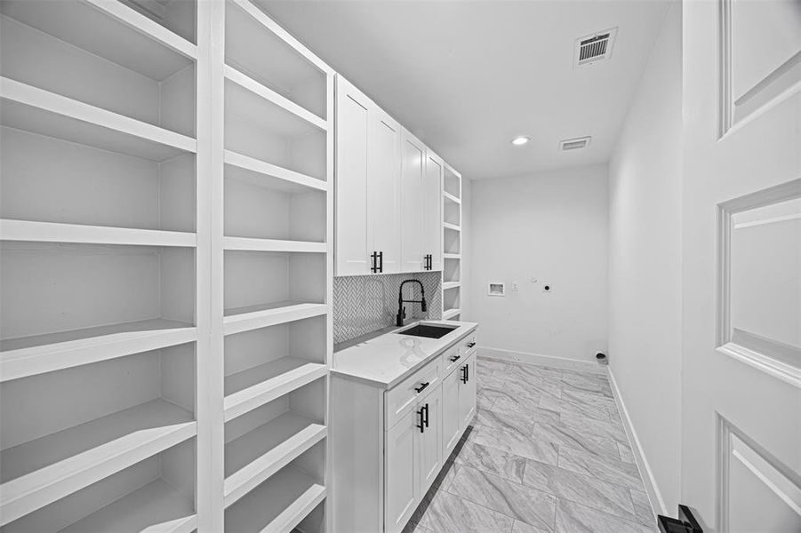 In house utility room with sink, shelves and storage space