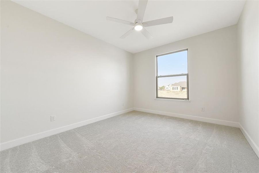 Carpeted spare room with ceiling fan