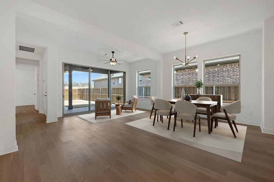 Dining area with ceiling fan, a chandelier, and dark wood-type flooring
