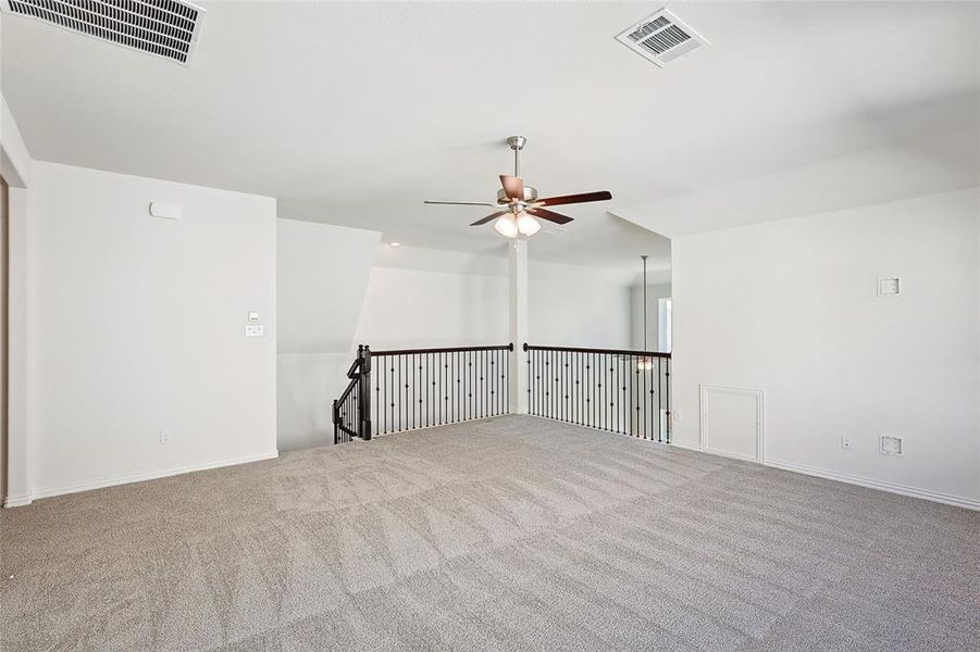 Unfurnished living room featuring lofted ceiling, ceiling fan, and carpet