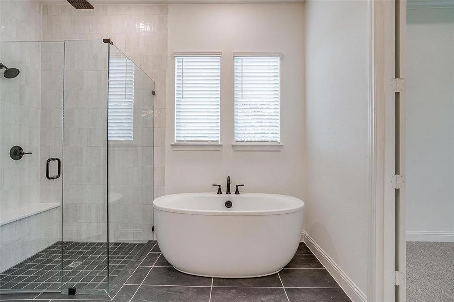 Bathroom with tile patterned floors and a shower with door