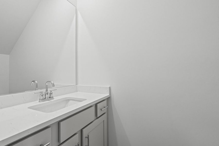 Vanity with light-toned cabinetry, an undermount sink, and a chrome faucet