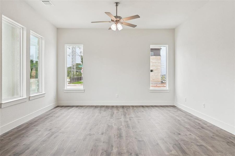 Unfurnished room with ceiling fan and light hardwood / wood-style floors