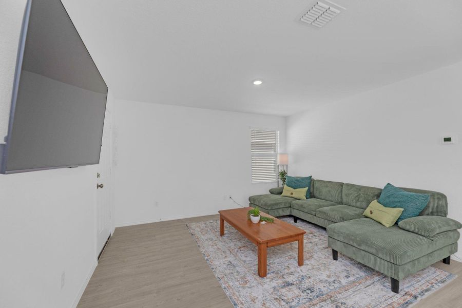 Spacious living room featuring vinyl flooring, and natural light.
