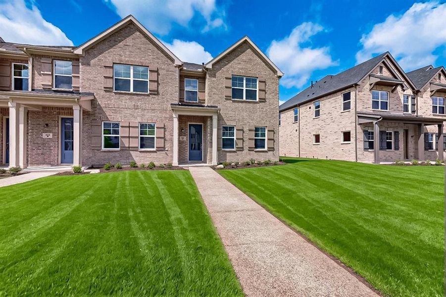 View of front of home featuring a front lawn and brick siding