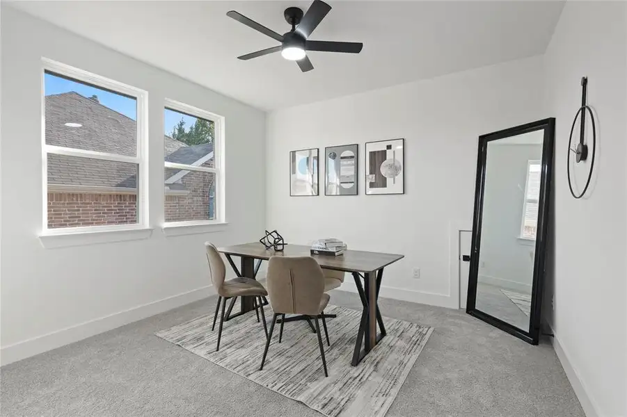 Dining area featuring light carpet and ceiling fan