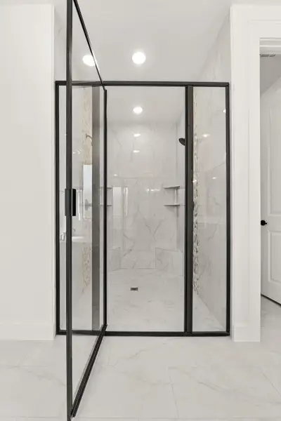 Full bathroom featuring a marble finish shower, light marble finish floors, and recessed lighting