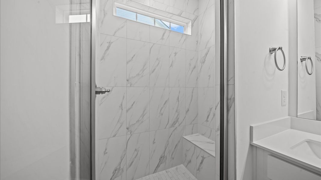Exceptional en-suite with dual vanity and glass-enclosed tiled walk-in shower for superior everyday comfort