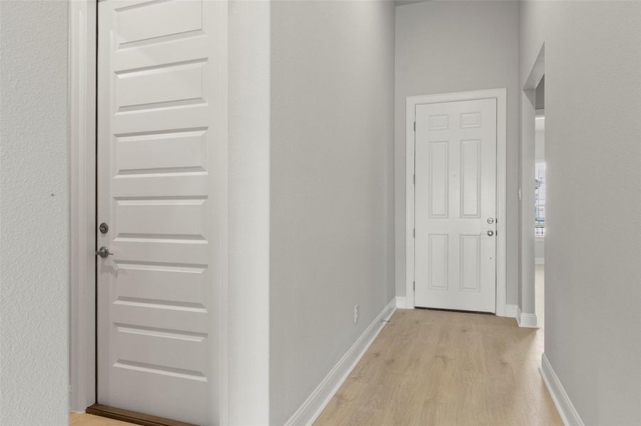 Hallway featuring light wood finished floors and baseboards
