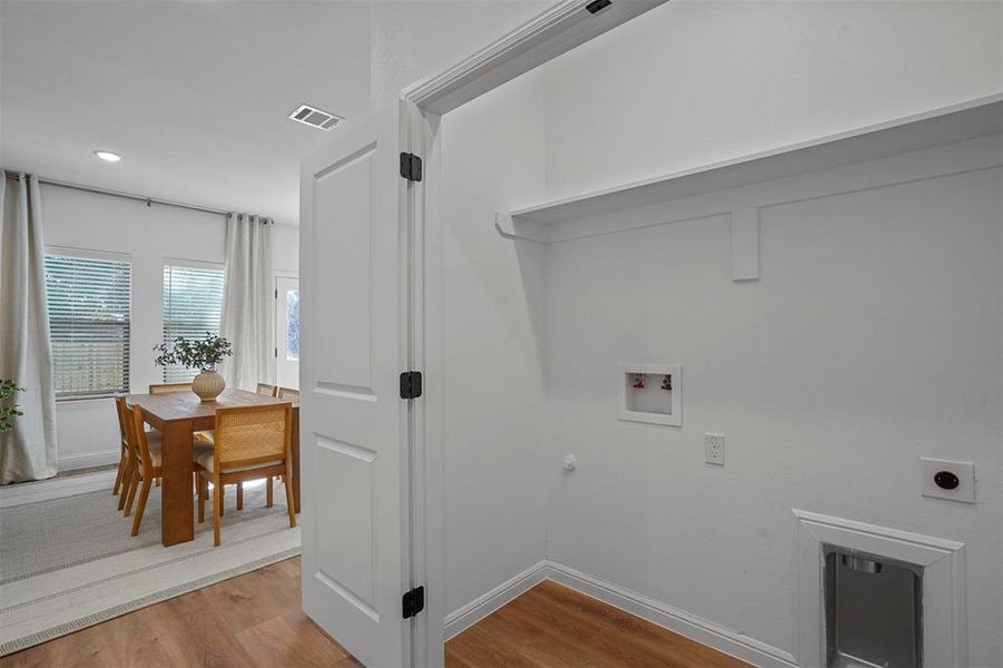 Laundry room with hookup for a gas dryer, hookup for an electric dryer, washer hookup, and light wood-type flooring