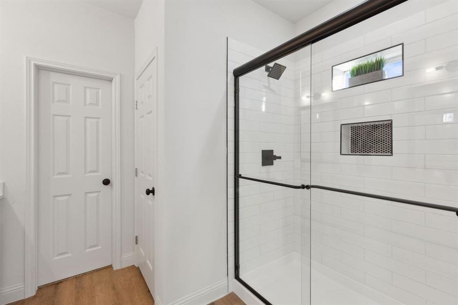 Bathroom with hardwood / wood-style floors and a shower with door