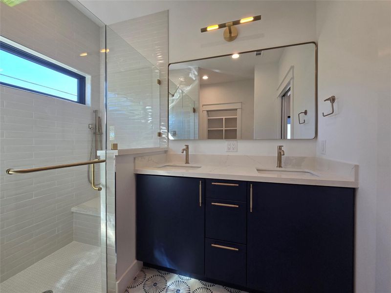 Multi function grab bar/towel holder on the glass shower door, and a large sitting bench inside the shower. Multi function grab bar/towel holder on the glass shower door, and a large sitting bench inside the shower.