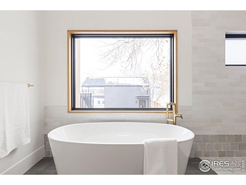 Free standing vessel tub perfectly placed under 4x8 window.