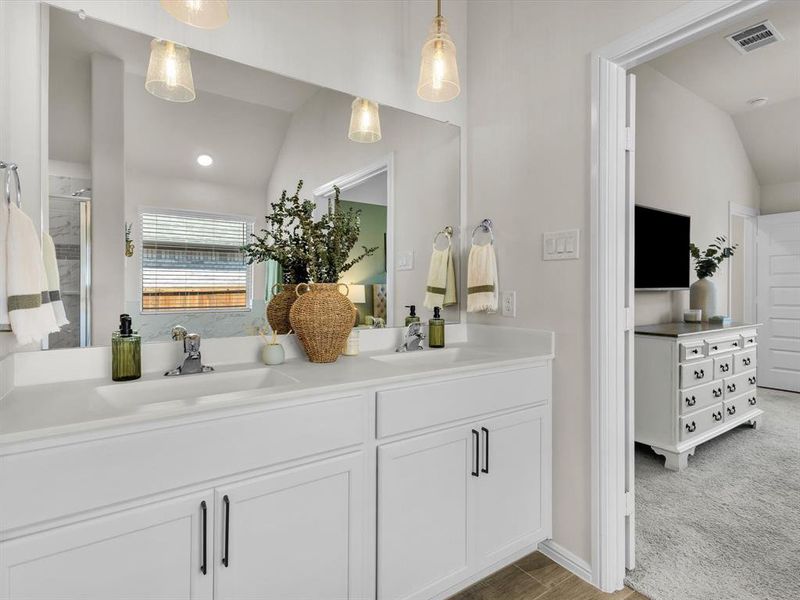 Modern pendant lighting highlights the dual sinks and hardware.