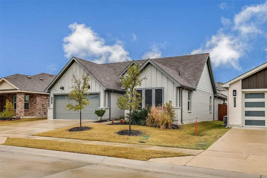 View of front of property with board and batten siding, brick siding, a shingled roof, and concrete driveway View of front of property with board and batten siding, brick siding, a shingled roof, and concrete driveway