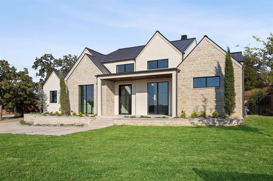 View of front of house with stone siding, a standing seam roof, a metal roof, and covered porch View of front of house with stone siding, a standing seam roof, a metal roof, and covered porch