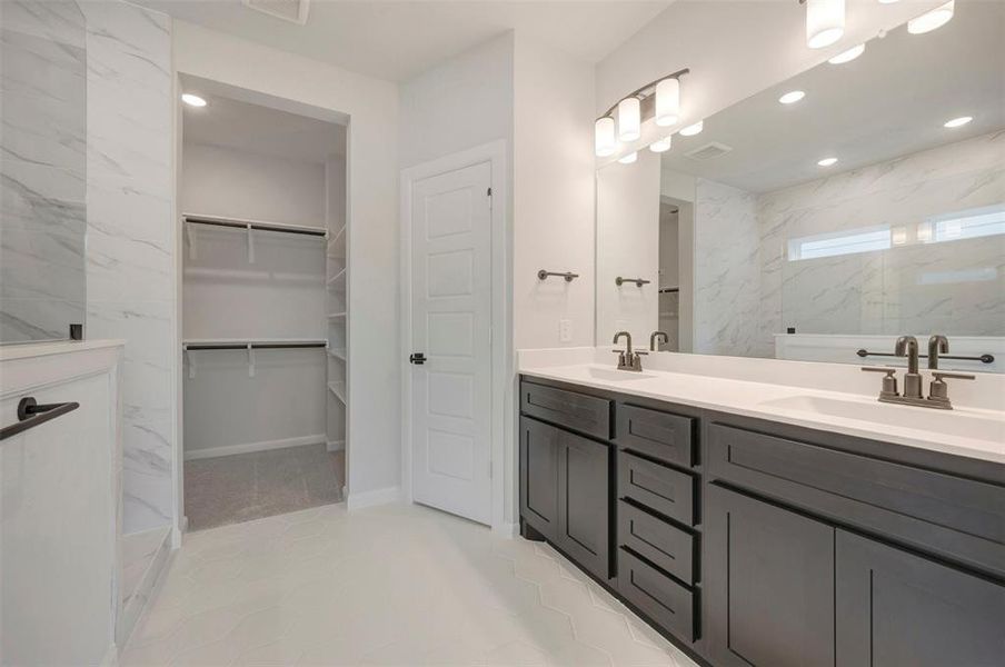 Bathroom featuring a double vanity with dark wood-finish cabinetry and white countertops Bathroom featuring a double vanity with dark wood-finish cabinetry and white countertops