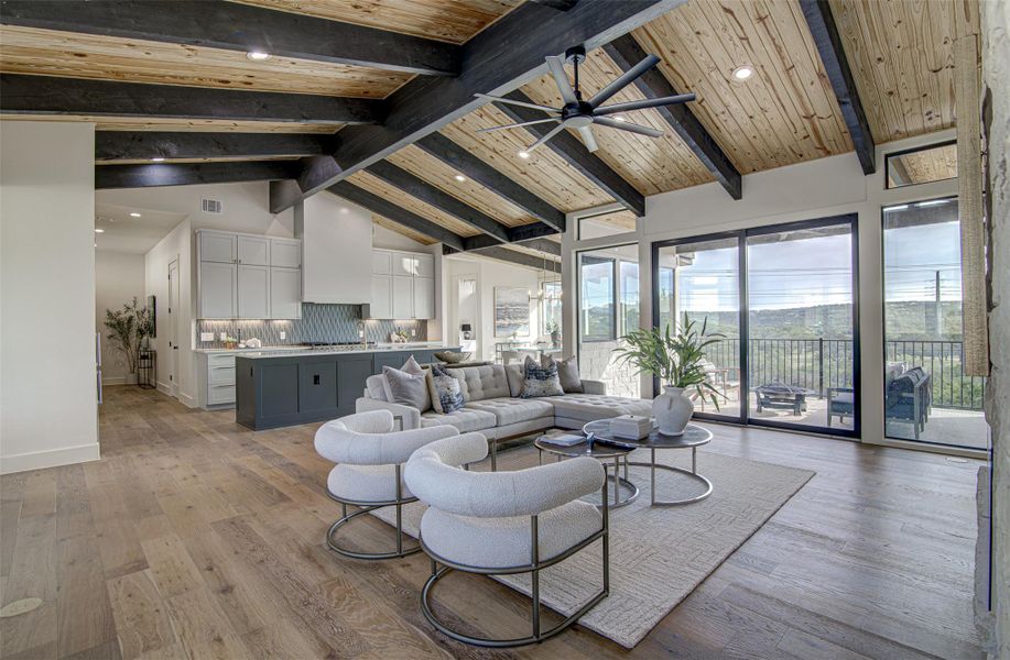 Living area with high vaulted ceiling, baseboards, light wood finished floors, a ceiling fan, and recessed lighting Living area with high vaulted ceiling, baseboards, light wood finished floors, a ceiling fan, and recessed lighting