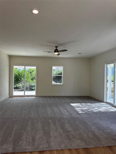 Carpeted empty room with ceiling fan, recessed lighting, and wood finished floors Carpeted empty room with ceiling fan, recessed lighting, and wood finished floors