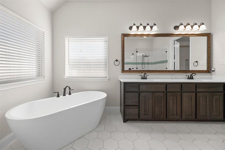 Bathroom featuring vanity, tile patterned floors, lofted ceiling, and shower with separate bathtub Bathroom featuring vanity, tile patterned floors, lofted ceiling, and shower with separate bathtub