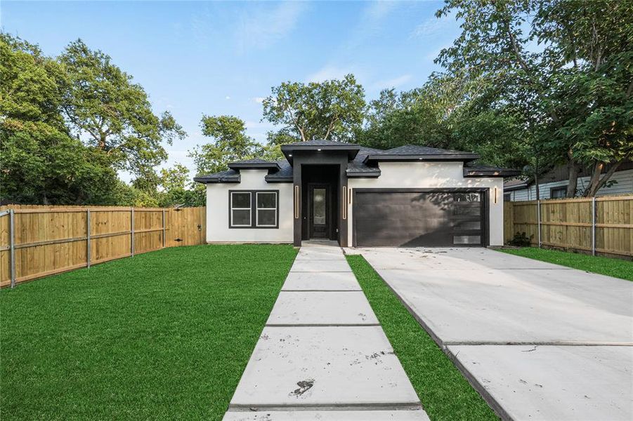 View of front of property with a front yard and a garage